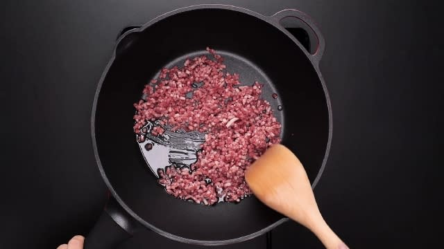 Stir frying minced beef with a wooden spatula