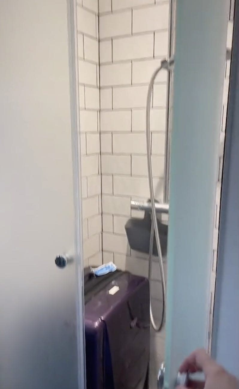 Screenshot of shower, with a suitcase in it.