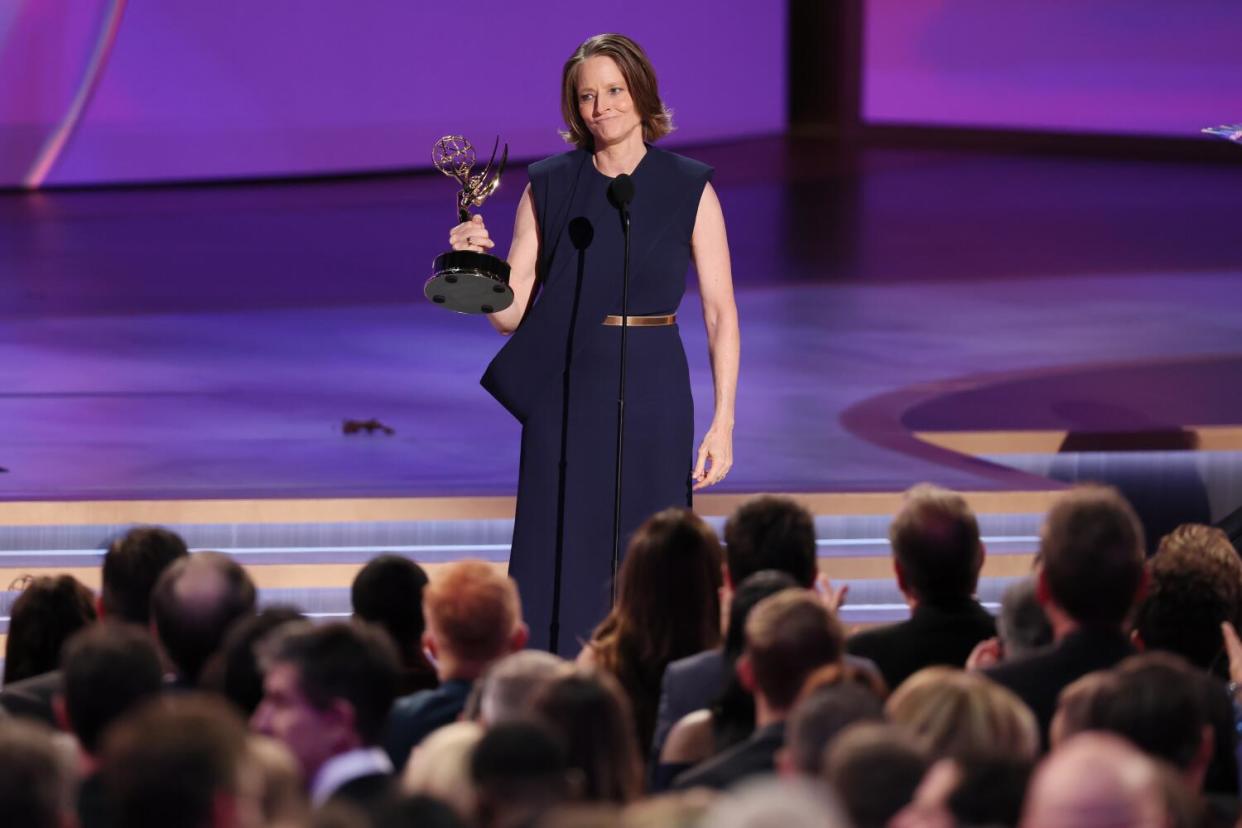 Jodie Foster stands onstage holding an Emmy