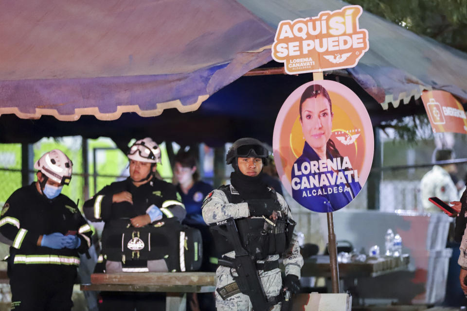 Relief workers and security forces stand next to electoral posters after a stage collapsed due to a gust of wind during an event attended by presidential candidate Jorge Álvarez Máynez in San Pedro Garza García, on the outskirts of Monterrey, Mexico, Wednesday, May 22, 2024. President Andres Manuel Lopez Obrador confirmed that four people were killed and at least a dozen were injured. (AP Photo/Alberto Lopez)