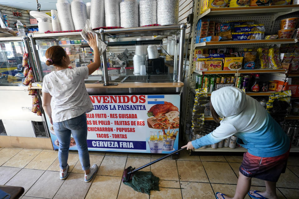 Workers at Los Primos La Paisanita continue the clean up of their store front after flash floods from the remnants of Ida inundated their community, Saturday, Sept. 4, 2021, in Mamaroneck, N.Y. More than four days after the hurricane blew ashore in Louisiana, Ida's rainy remains hit the Northeast with stunning fury on Wednesday and Thursday, submerging cars, swamping subway stations and basement apartments and drowning scores of people in five states. (AP Photo/Mary Altaffer)