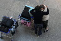 A couple embrace at Lisbon's international airport, Tuesday, Nov. 30, 2021. Portugal is bringing back some tight pandemic restrictions, less than two months after scrapping most of them when the goal of vaccinating 86% of the population against COVID-19 was reached. (AP Photo/Armando Franca)