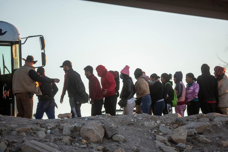 Migrants are loaded onto Customs and Border Protection buses in El Paso after having spent the night in the north embankment of the Rio Grande after crossing en mass on Sunday Dec. 11, 2022. 