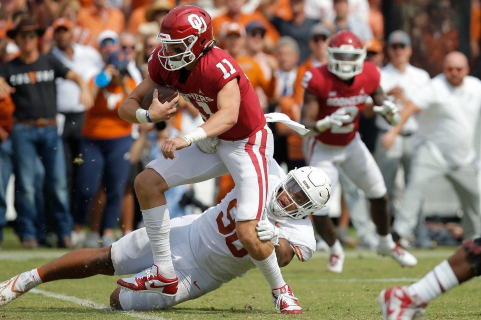 Texas defensive lineman Byron Murphy II (90) brings down Oklahoma quarterback Davis Beville (11) during their 2022 game at the Cotton Bowl in Dallas,