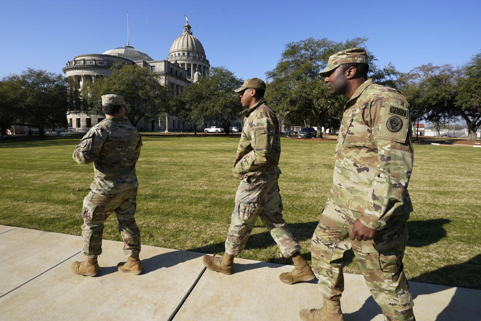 Members of the Mississippi National Guard keep their distance from the Mississippi State Capitol, Thursday morning, Jan. 4, 2024, as Capitol Police deal with a second day of bomb threats to the state house and the Carroll Gartin Justice Building, which houses the state supreme and appellate courts. The guardsmen are support staff involved with Tuesday's inauguration of Gov. Tate Reeves at the Capitol. (AP Photo/Rogelio V. Solis)