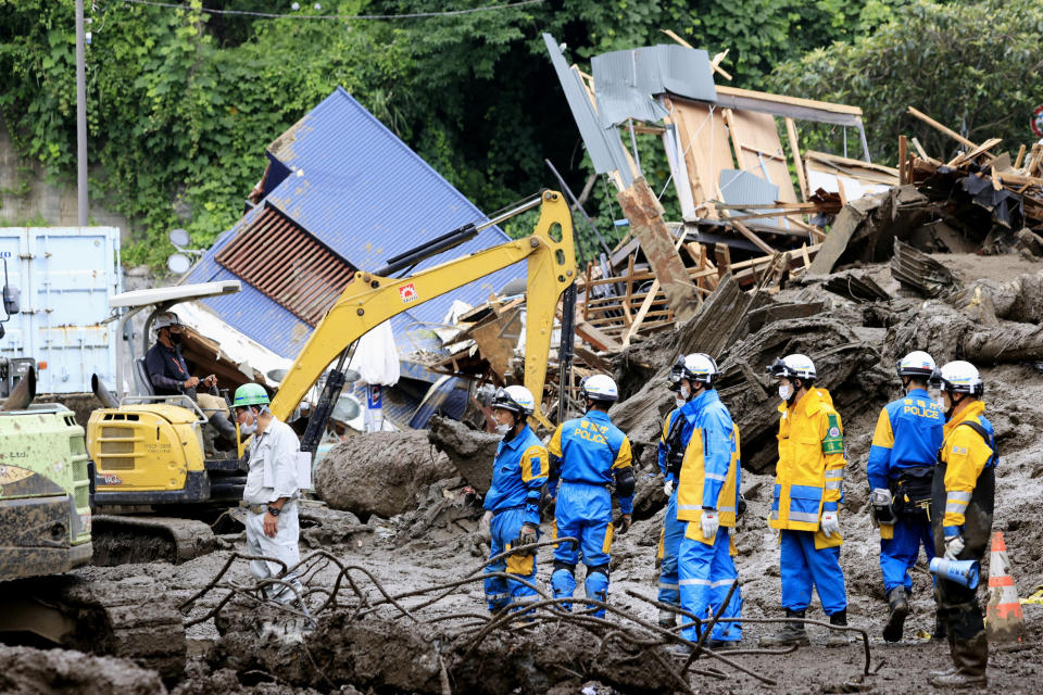 Police officers continue a search operation for missing people at the site of a mudslide in Atami, southwest of Tokyo Tuesday, July 6, 2021. Rescue workers struggled with sticky mud and risks of more mudslides Tuesday as they searched for people may have been trapped after a torrent of mud that ripped through a seaside hot springs resort. (Kyodo News via AP)