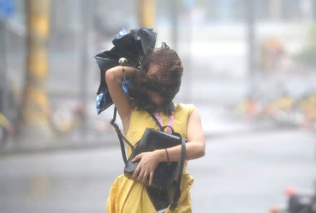 A woman walks in the rainstorm as Typhoon Mangkhut approaches, in Shenzhen, China September 16, 2018. REUTERS/Jason Lee
