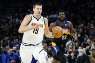 Denver Nuggets center Nikola Jokic (15) moves the ball up court as Phoenix Suns center Deandre Ayton (22) pursues during the first half of an NBA basketball game, Wednesday, Oct. 20, 2021, in Phoenix. (AP Photo/Matt York)