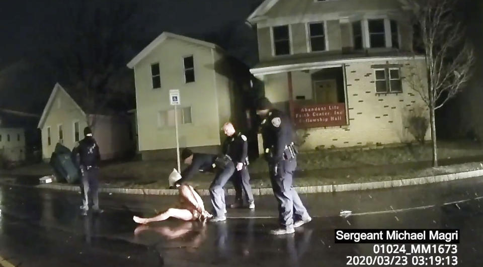 FILE- In this March 23, 2020 image made from police body camera video, provided by Roth and Roth LLP, a Rochester police officer puts a hood over the head of Daniel Prude in Rochester, N.Y. Newly released transcripts show that a grand jury investigating the police suffocation death of Daniel Prude last year in Rochester, New York, voted 15-5 to clear the three officers involved in his restraint of a criminally negligent homicide charge sought by prosecutors. (Rochester Police via Roth and Roth LLP via AP, File)