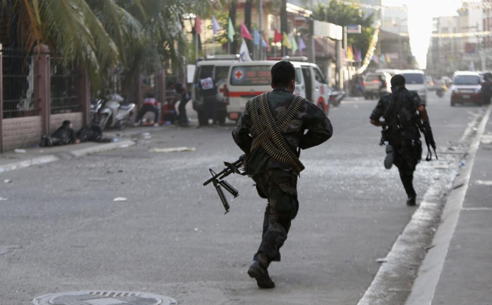 Government soldiers run for cover as their comrades (L) lie on the ground after they were wounded in a mortar attack by Muslim rebels at the scene of fighting between government soldiers and Muslim rebels from the Moro National Liberation Front (MNLF) in Zamboanga city in southern Philippines September 13, 2013. (REUTERS/Erik De Castro)