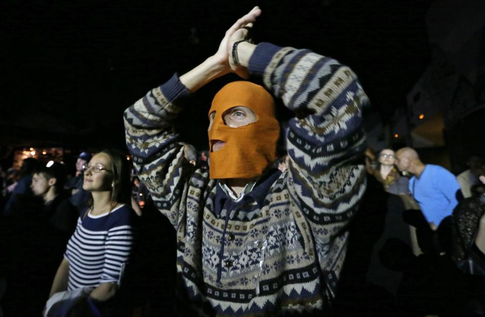 A masked spectator reacts during the concert organized to support jailed Pussy Riot musicians in St.Petersburg, Russia, Sunday, Sept. 9, 2012. A Moscow judge has sentenced each of three members of the provocative punk band Pussy Riot to two years in prison on hooliganism charges following a trial that has drawn international outrage as an emblem of Russia's intolerance to dissent. (AP Photo/Dmitry Lovetsky)