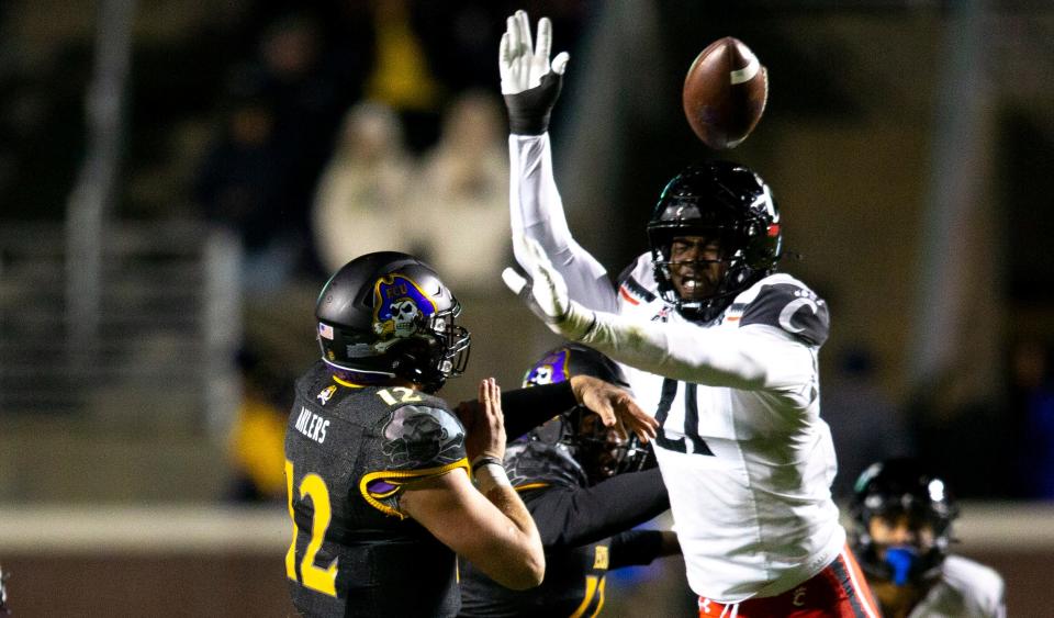 Cincinnati Bearcats defensive lineman Myjai Sanders (21) deflects a pass by East Carolina Pirates quarterback Holton Ahlers (12) in the second half of the NCAA football game at Dowdy-Ficklen Stadium in Greenville, NC, on Friday, Nov. 26, 2021. Cincinnati Bearcats defeated East Carolina Pirates 35-13. 