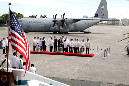 Philippine defence officials and U.S. Embassy officials inspect the bells of Balangiga after their arrival at Villamor Air Base in Pasay, Metro Manila, Philippines December 11, 2018. REUTERS/Erik De Castro
