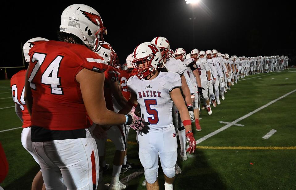 Natick's Jake Adelmann, right, and Milford's Marco Monteiro shake hands after the Scarlet Hawks beat the Redhawks 21-7 to advance to the final four of the MIAA  Division 2 playoffs, at Milford High School, Nov. 11, 2021.  