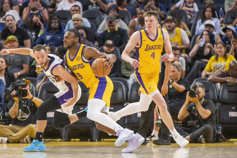 Sacramento Kings guard Jordan Ford (31) blocks Los Angeles Lakers guard Bronny James (9) as guard Dalton Knecht (4) looks on during the first half of an NBA summer league basketball game in San Francisco, Saturday, July 6, 2024. (AP Photo/Nic Coury)