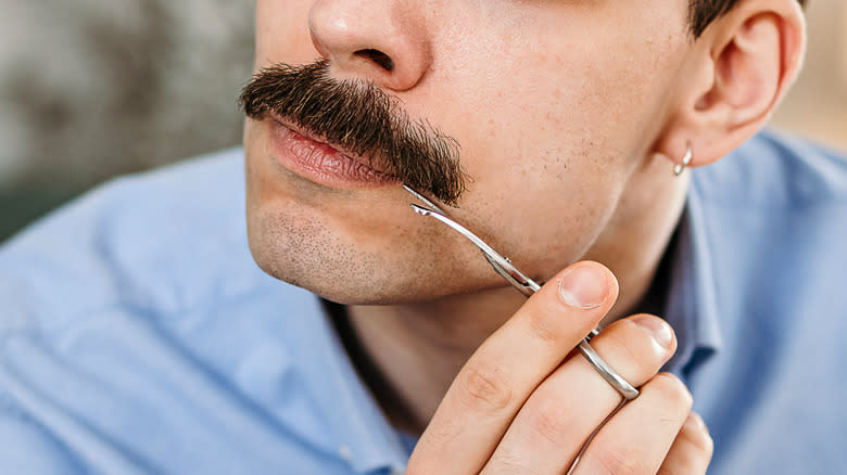 Person trimming mustache