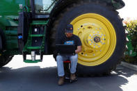 Bryon Majusiak, a senior mechanical engineer with Blue River Technology, works on his computer next to a tractor as others assemble a See & Spray agricultural machine that combines computer vision and artificial intelligence to detect and precisely spray herbicides onto weeds in a farm field in Sunnyvale, California, April 23, 2018. REUTERS/ Stephen Lam