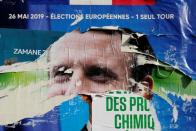 FILE PHOTO: Torn and overlapping official posters of candidates for the 2019 European parliament elections including a poster of French President Emmanuel Macron as the cover for the Renaissance (Renewal) list, are seen in Cambrai