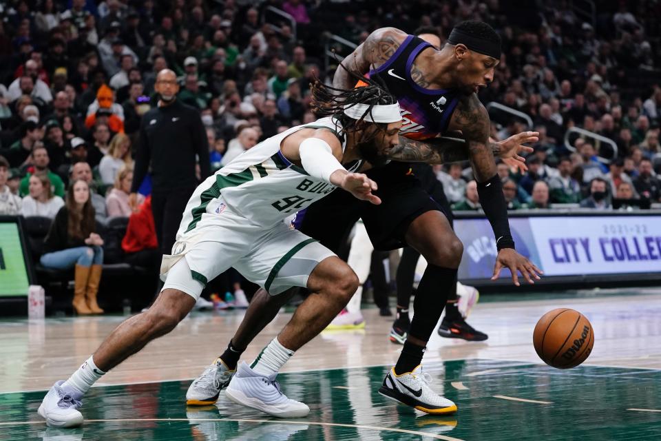 Milwaukee Bucks' DeAndre' Bembry and Phoenix Suns' Torrey Craig go after a loose ball during the first half of an NBA basketball game Sunday, March 6, 2022, in Milwaukee . (AP Photo/Morry Gash)