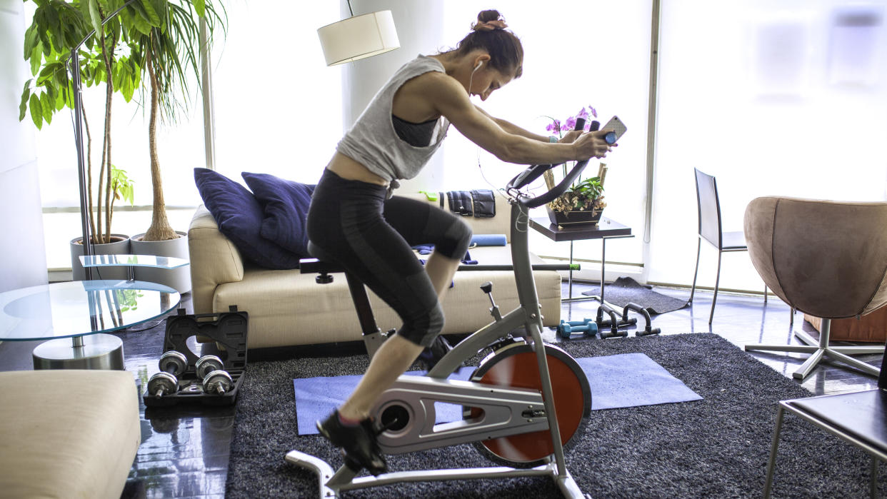  Should you buy an exercise bike? Image shows woman on exercise bike at home 