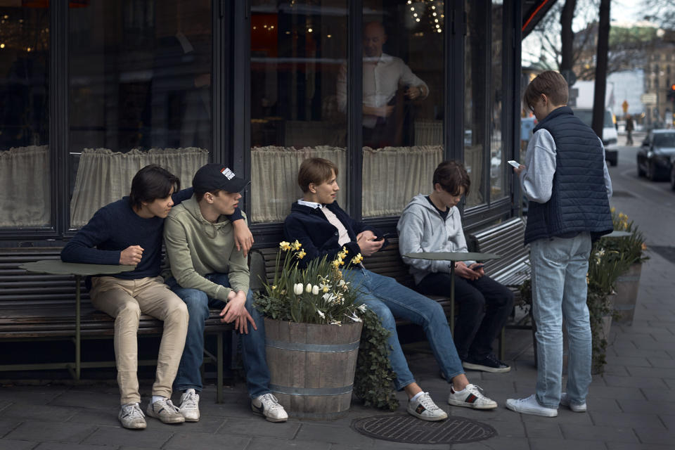FILE - In this Wednesday, April 8, 2020 file photo youths hang out outside a restaurant in Stockholm, Sweden. (AP Photo/Andres Kudacki, File)