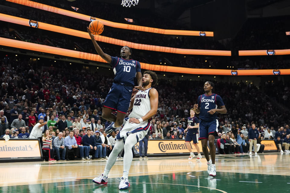 UConn guard Hassan Diarra (10) shoots next to Gonzaga forward Anton Watson (22) as UConn's Tristen Newton (2) watches during the second half of an NCAA college basketball game Friday, Dec. 15, 2023, in Seattle. (AP Photo/Lindsey Wasson)