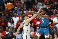 El escolta de Nuevo México, Jamal Mashburn Jr., pasa el balón mientras el escolta del estado de Utah, Mason Falslev, defiende durante la primera mitad de un partido de baloncesto universitario de la NCAA el martes 16 de enero de 2024 en Albuquerque, Nuevo México (Foto AP/Eric Draper)