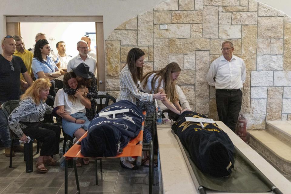 Mourners attend the funeral of two British-Israeli sisters, Maia and Rina Dee, at a cemetery in the West Bank Jewish settlement of Kfar Etzion, Sunday, April 9, 2023. The two sisters were killed in a shooting attack on Friday by Palestinian gunmen in the West Bank. (AP Photo/Ohad Zwigenberg)