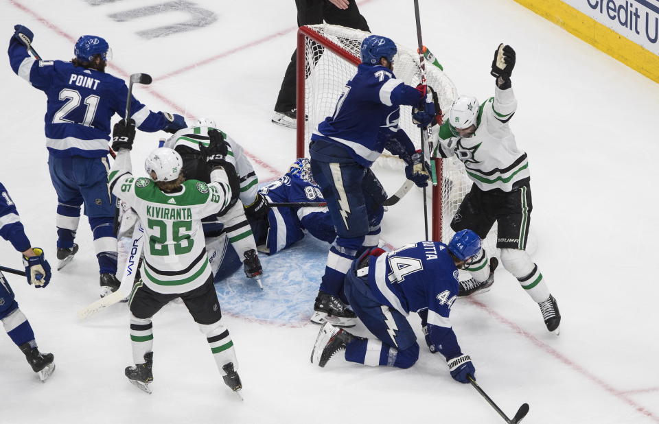 Dallas Stars left wing Joel Kiviranta (25) and center Tyler Seguin (91) celebrate a goal against the Tampa Bay Lightning right wing Corey Perry, obscured, in front of Kiviranta, during the second overtime period NHL Stanley Cup finals action in Edmonton on Saturday, September 26, 2020. THE CANADIAN PRESS/Jason Franson/The Canadian Press via AP)