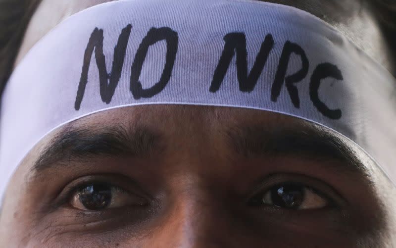 A man wearing a headband attends a protest march against a new citizenship law, on the outskirts of Mumbai