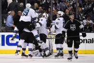 Members of the San Jose Sharks, left, celebrate a game-winning goal by center Patrick Marleau as Los Angeles Kings center Tyler Toffoli, right, looks on during the overtime period in Game 3 of an NHL hockey first-round playoff series, Tuesday, April 22, 2014, in Los Angeles. The Sharks won 4-3. (AP Photo/Mark J. Terrill)