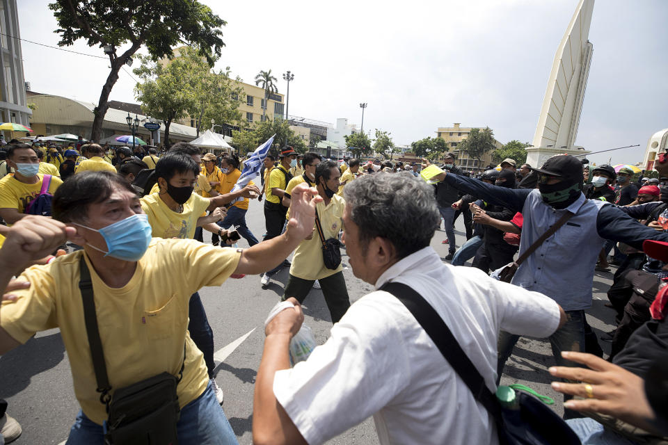 A pro-democracy protester, right, and and a supporter of the monarchy, in yellow, exchange blows at a rally near the Democracy Monument in Bangkok, Thailand, Wednesday, Oct. 14, 2020. Thousands of anti-government protesters gathered Wednesday for a rally at Bangkok’s Democracy Monument being held on the anniversary of a 1973 popular uprising that led to the ousting of a military dictatorship, amid a heavy police presence and fear of clashes with political opponents.(AP Photo/Wason Wanichakorn)