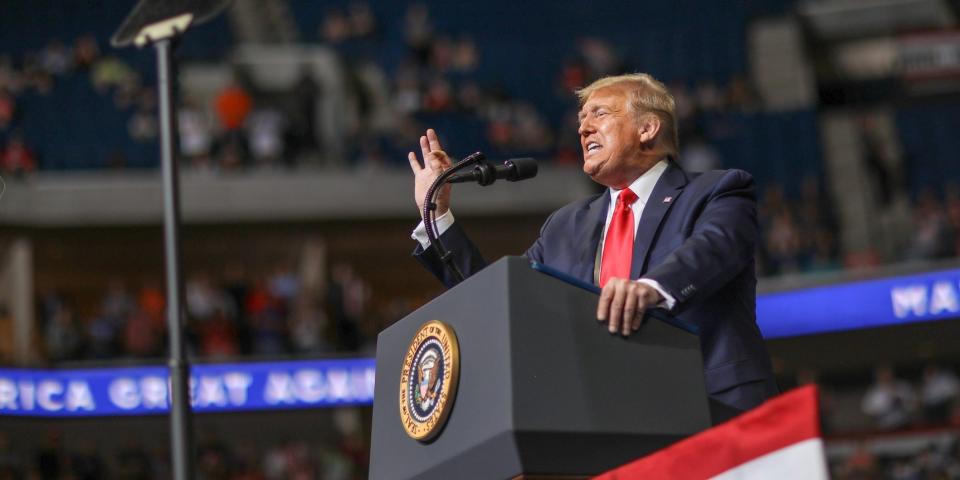 Donald Trump speaking at a lectern with the presidential seal in an arena in Tulsa, Oklahoma.