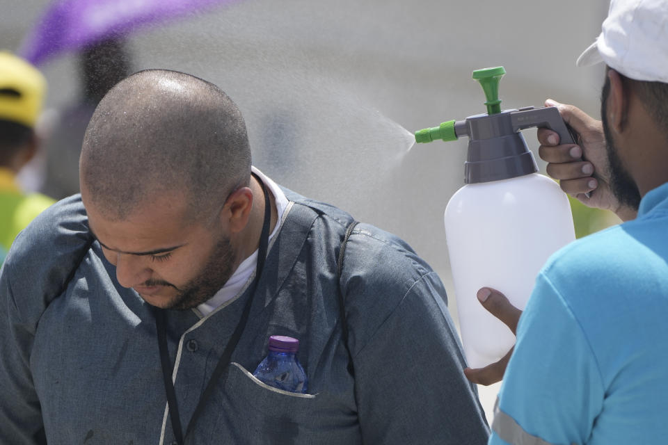 A pilgrim receives cold water spray after he casts stones at a pillar in the symbolic stoning of the devil, the last rite of the annual Hajj pilgrimage, in Mina near the holly city of Mecca, Saudi Arabia, Thursday, June 29, 2023. (AP Photo/Amr Nabil)