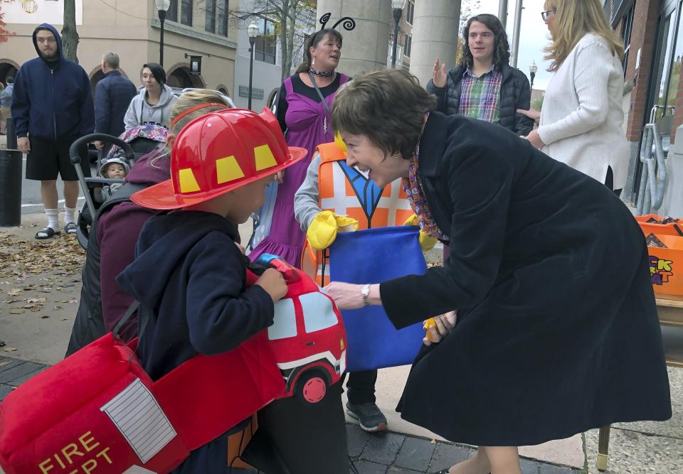 In this Friday, Oct. 25, 2019 photo, Sen. Susan Collins, R-Maine, hands out candy to children outside her office during a trick-or-treat event hosted by the local chamber of commerce in Lewiston, Maine. Collins is expected to make a formal announcement on her reelection plans later this fall. (AP Photo/David Sharp)