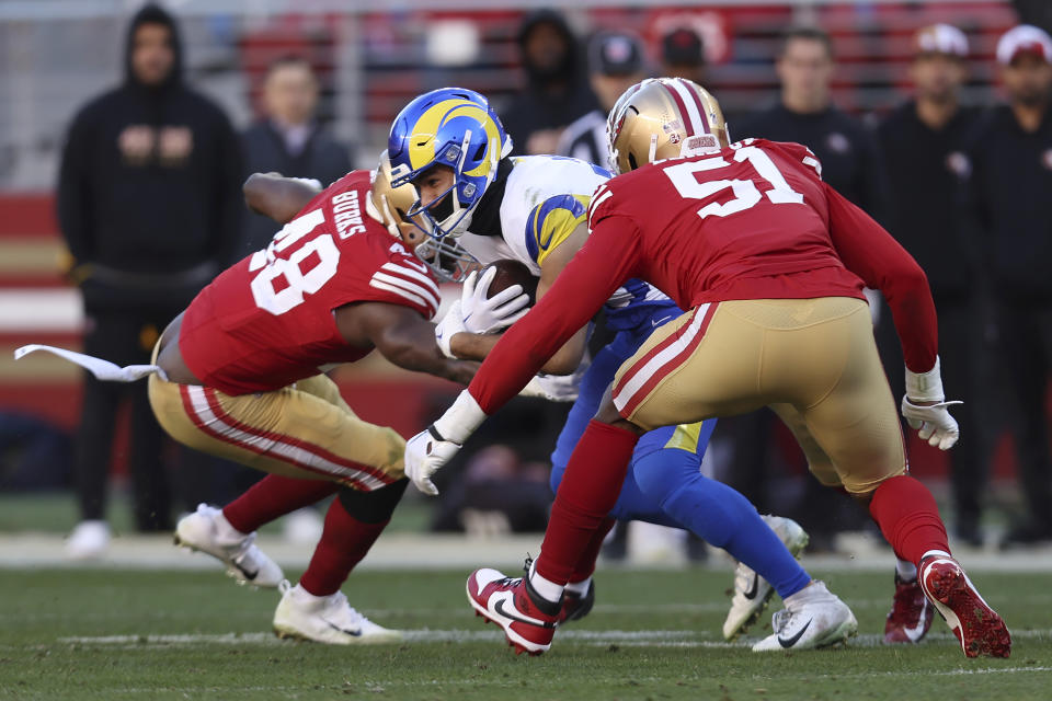 Los Angeles Rams wide receiver Puka Nacua, middle, runs after catching a pass against the San Francisco 49ers during the second half of an NFL football game in Santa Clara, Calif., Sunday, Jan. 7, 2024. Nacua set a rookie record for receiving yards on this play. (AP Photo/Jed Jacobsohn)