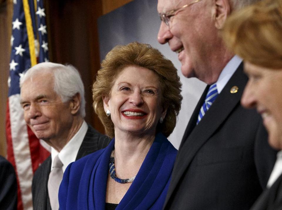 Senate Agriculture Committee Chair Sen. Debbie Stabenow, D-Mich., second from left, celebrates with fellow committee members during a news conference on Capitol Hill in Washington, Tuesday, Feb. 4, 2014, after Congress gave its final approval to a sweeping five-year farm bill. From left are, the committee's ranking member Sen. Thad Cochran, R-Miss., Stabenow, Sen. Patrick Leahy, D-Vt., and Sen. Heidi Heitkamp, D-N.D. (AP Photo/J. Scott Applewhite) (AP Photo/J. Scott Applewhite)