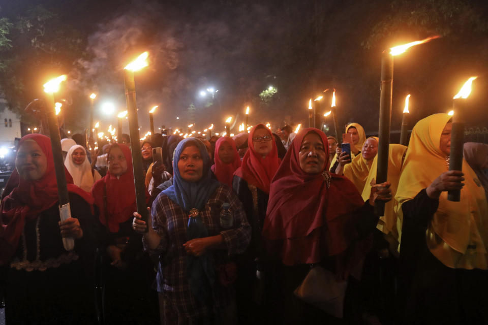 Muslim women hold torches during a parade ahead of the beginning of the holy month of Ramadan in Medan, North Sumatra, Indonesia, Saturday, March 18, 2023. Muslims around the world will start to observe the holiest month in Islamic calendar next week during which they refrain from eating, drinking, smoking and sex from dawn to dusk. (AP Photo/Binsar Bakkara)