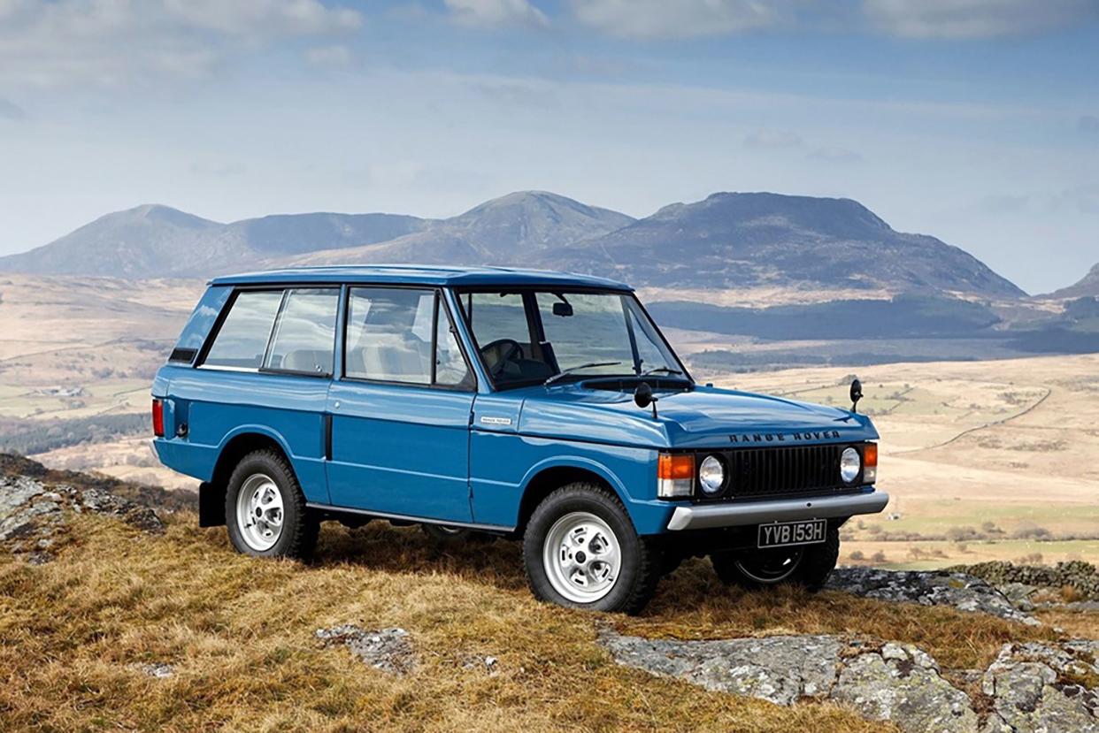 Blue 1971 Range Rover parked in a desert with mountains in background