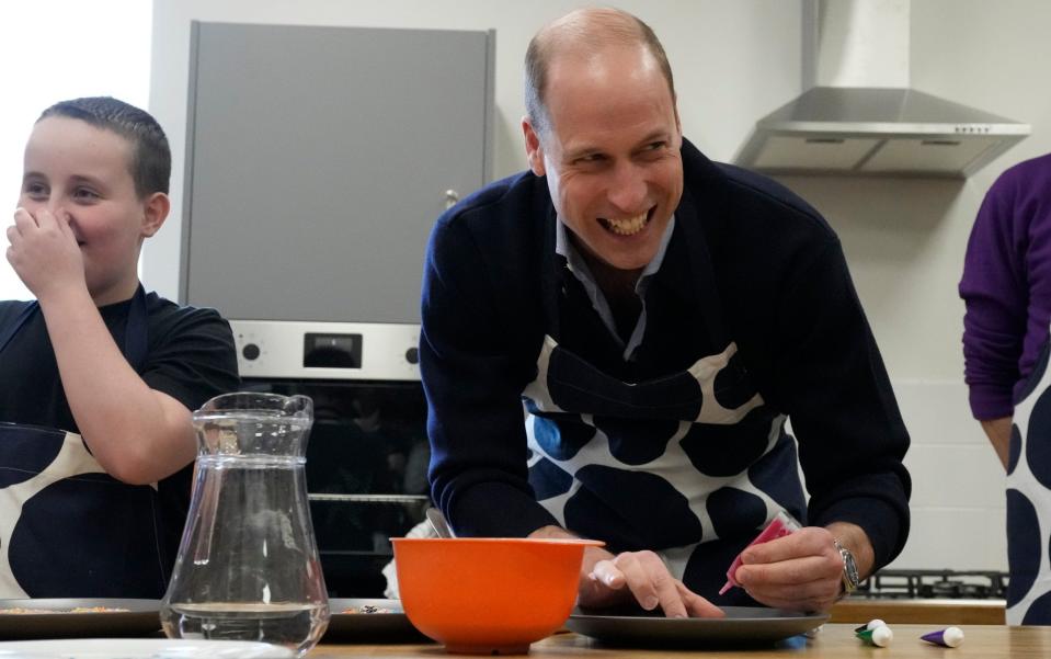 The Prince tries his hand at decorating biscuits during his visit to the youth club in west London