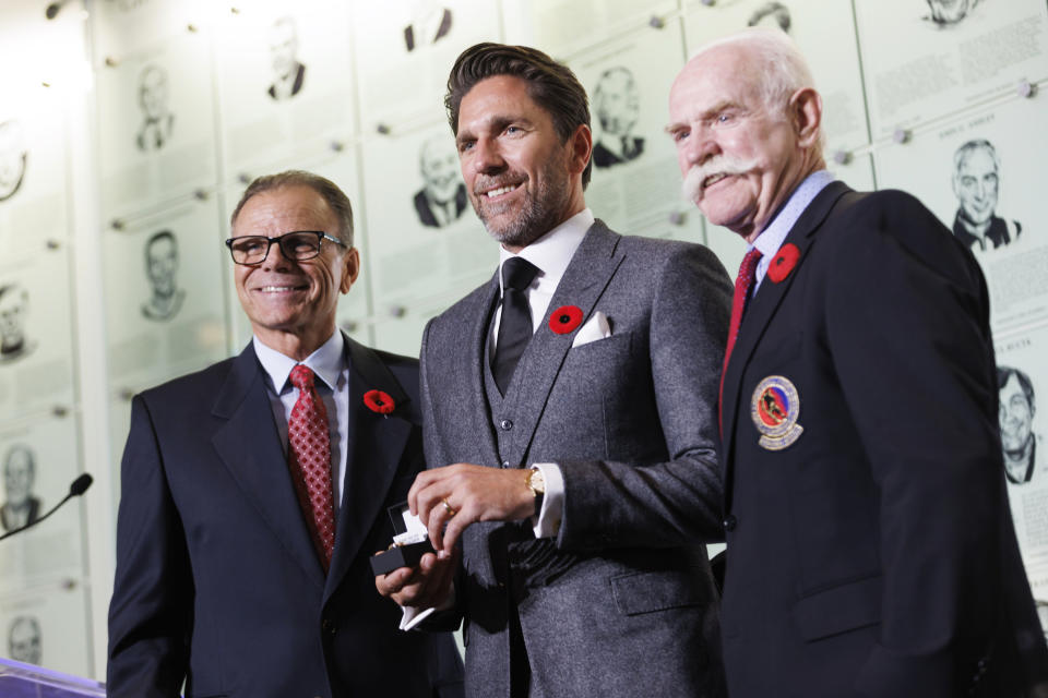 Hockey Hall of Fame 2023 inductee Henrik Lundqvist, center, receives his Hockey Hall of Fame ring from Mike Gartner, left, and Lanny McDonald as he's inducted into the Hall in Toronto Friday, Nov. 10, 2023. (Cole Burston/The Canadian Press via AP)