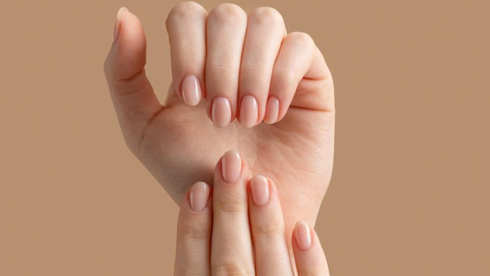 Hands with shiny, beige nail polish