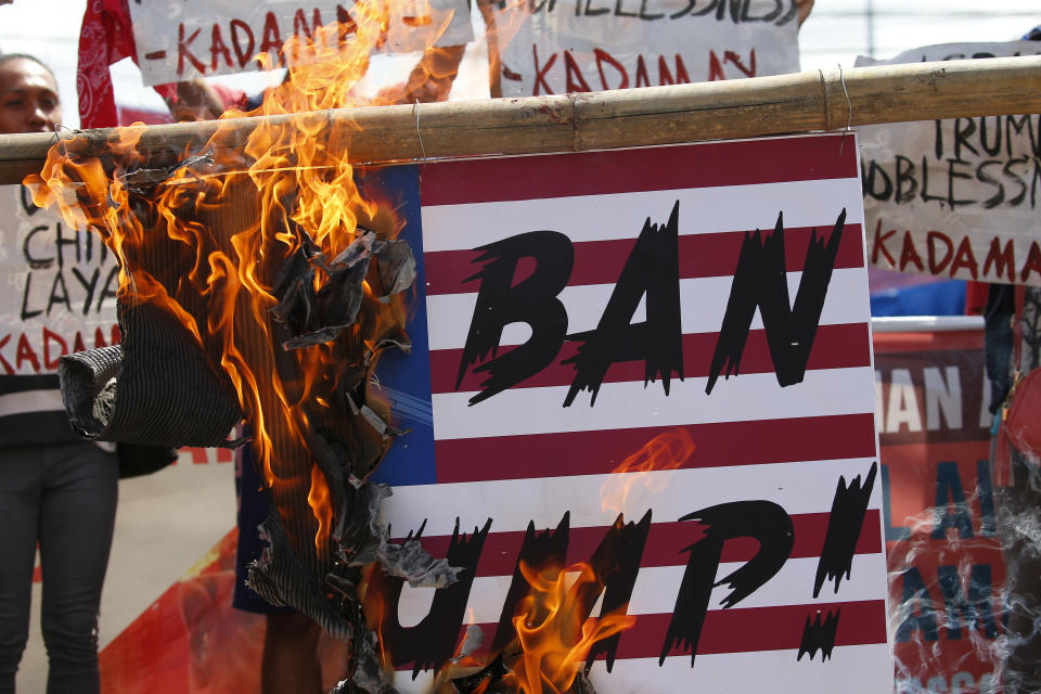 <p>Protesters, who have been camping out near the Presidential Palace for days, set on fire to a mock U.S. flag during a rally to protest a planned visit to the country of President Donald Trump Tuesday, Nov. 7, 2017 in Manila, Philippines.(Photo: Bullit Marquez/AP) </p>