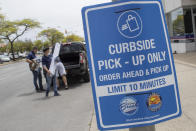 A reserved parking for curb-side pick-up sign is seen, Wednesday, May 27, 2020, in Long Beach, N.Y. Long Island has become the latest region of New York to begin easing restrictions put in place to curb the spread of the coronavirus as it enters the first phase of the state's four-step reopening process. (AP Photo/Mary Altaffer)
