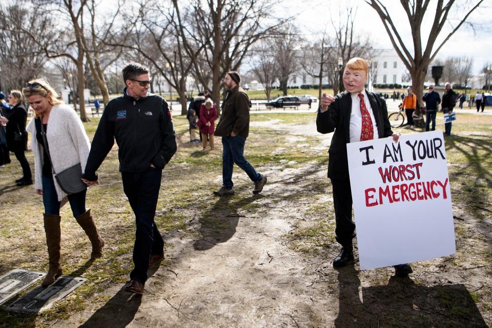 People look at an activist dressed in effigy of US President Donald Trump during a protest during Presidents' Day in Lafayette Square, near the White House on Feb. 18, 2019 in Washington, D.C. (Photo: Brendan Smialowski/AFP/Getty Images)