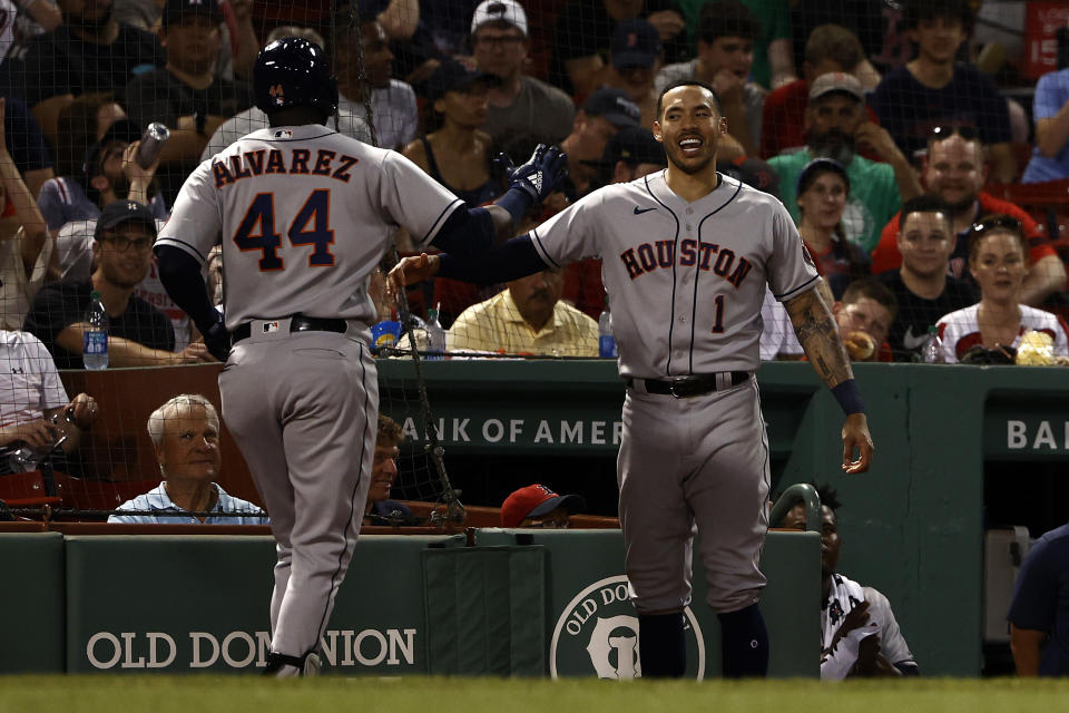 Houston Astros' Carlos Correa, right, greets Yordan Alvarez, left, at the dugout after his home run against the Boston Red Sox during the fourth inning of a baseball game Tuesday, June 8, 2021, at Fenway Park in Boston. (AP Photo/Winslow Townson)