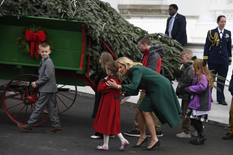 First lady Jill Biden walks with the children of military families as they view the arrival of the official 2023 White House Christmas Tree, at the White House on Monday. The 19-foot Fraser fir from Fleetwood, North Carolina, will stand floor to ceiling when it is decorated in the Blue Room. Photo by Mike Theiler/UPI