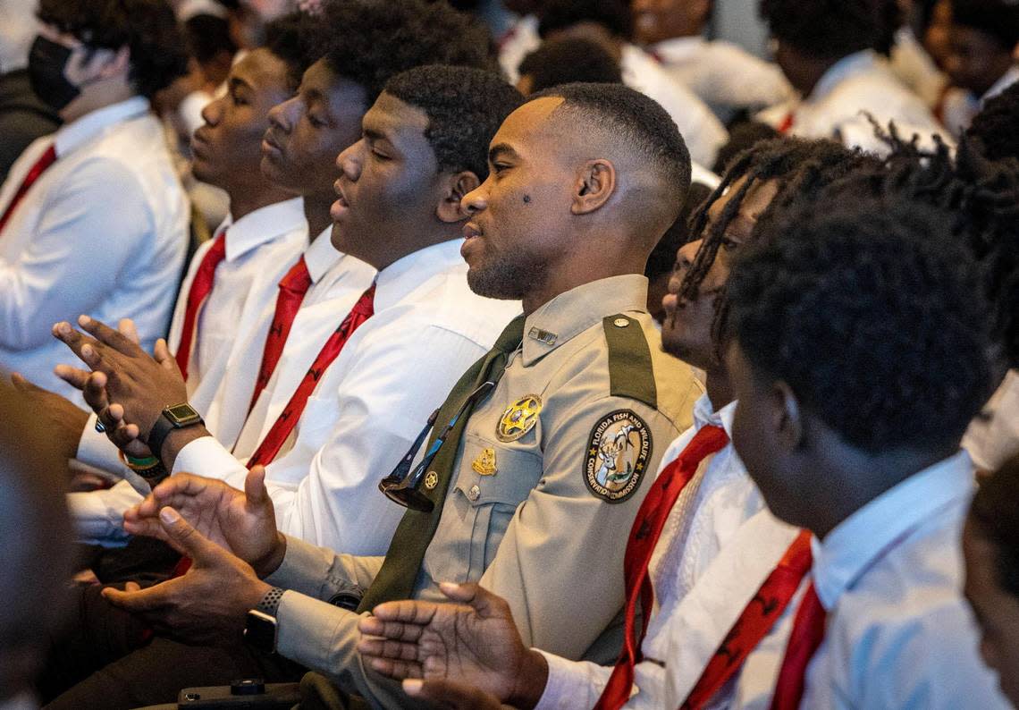 Officer Ronald Washington of the Florida Fish and Wildlife Conservation Commission, center, claps along with young men attending a 5000 Role Models conference at Hard Rock Stadium. The conference is designed to get young men of color interacting with police officers.