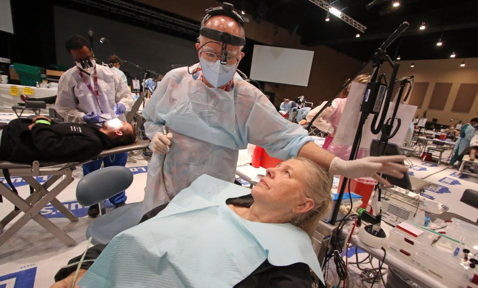Dentist Woody Bolinger talks with Dana Ware prior to her having restorative work done on her teeth as the North Carolina Dental Society held a Missions of Mercy free dental clinic Friday, Aug. 19, 2022, at City Church in Gastonia.