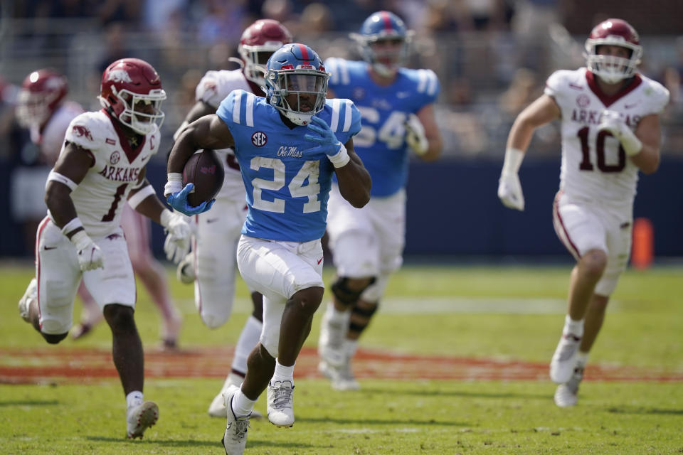 Mississippi running back Snoop Conner (24) runs past a host of Arkansas defenders on his way to a 51-yard touchdown run during the second half of an NCAA college football game, Saturday, Oct. 9, 2021, in Oxford, Miss. Mississippi won 52-51.(AP Photo/Rogelio V. Solis)